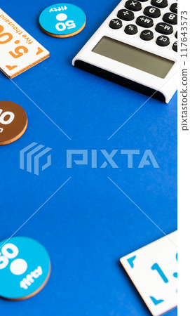 Calculator and toy money on a blue background - Image material for expenses and payments Calculator and toy money on a blue background - Image material for expenses and payments 117643573