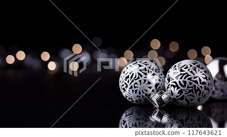 A pair of silver and black ornaments with a black background A pair of silver and black ornaments with a black background 117643621