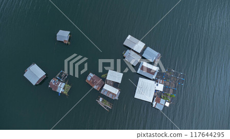 Aerial view of the River Kwai and floating houses in Kanchanaburi Province, Thailand. Beautiful view of floating cottages and Thai long-tail boats sailing on the River Kwai. Aerial view of the River Kwai and floating houses in Kanchanaburi Province, Thailand. Beautiful view of floating cottages and Thai long-tail boats sailing on the River Kwai. 117644295