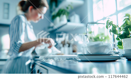 Washing dishes in a bright kitchen 117644462