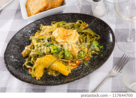 Authentic Italian fettuccine pasta dish with chicken breast and broccoli on table 117644700