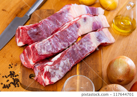Fresh raw pork ribs with potatoes, onions and black pepper on wooden table 117644701