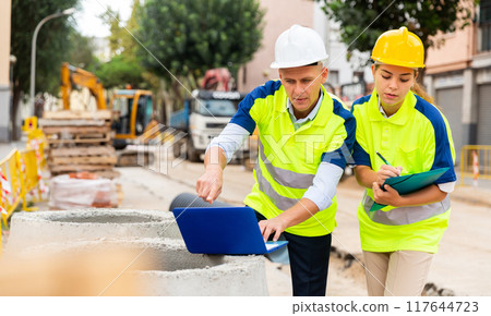 Two architects with laptop discussing construction plan 117644723