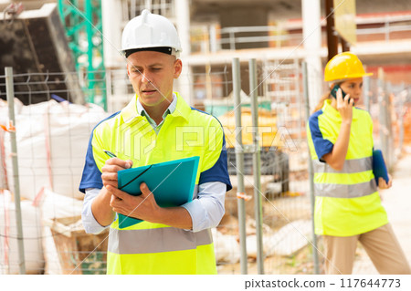 Young civil engineer makes important work notes 117644773