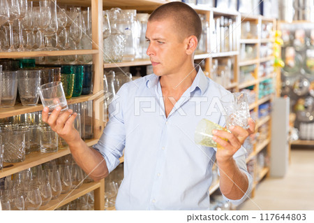 Man choosing glassware in store Man choosing glassware in store 117644803