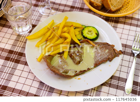 Steak with roquefort sauce with potatoes and zucchini 117645036