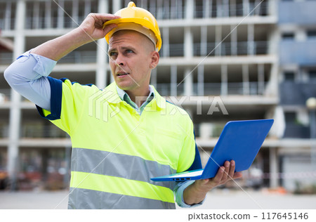 Portrait of a man engineer monitoring the progress of work on a laptop Portrait of a man engineer monitoring the progress of work on a laptop 117645146
