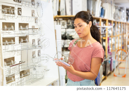 Asian woman choosing accessories for bathroom Asian woman choosing accessories for bathroom 117645175