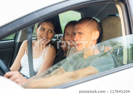 Portrait of happy family of three in car salon 117645204