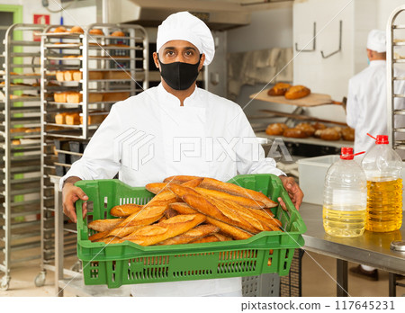 Portrait of baker in protective mask in bakery Portrait of baker in protective mask in bakery 117645231