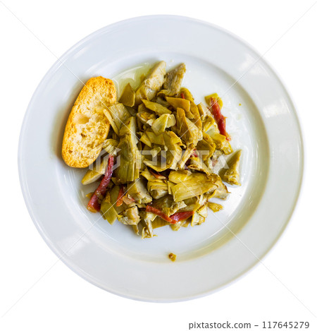 Dish of fried artichoke flowers and slices of ham is served on plate 117645279
