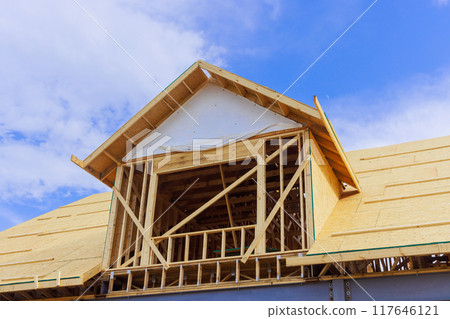 Installation plywood on wooden roofing trusses to house under construction Installation plywood on wooden roofing trusses to house under construction 117646121