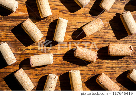 Wine cork stoppers arranged randomly on wooden surface. Wine cork stoppers arranged randomly on wooden surface. 117646419