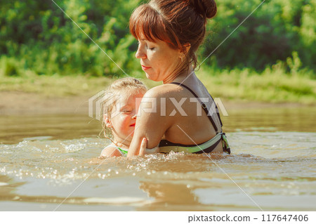 mom and child swim in the river mom and child swim in the river 117647406