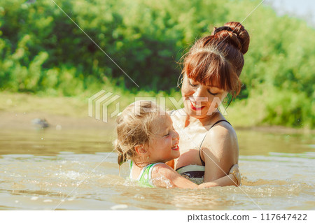 mom and child swim in the river mom and child swim in the river 117647422