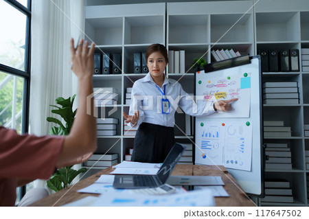 A businesswoman presents a marketing plan in the meeting room, strategically financial goals for successful execution A businesswoman presents a marketing plan in the meeting room, strategically financial goals for successful execution 117647502