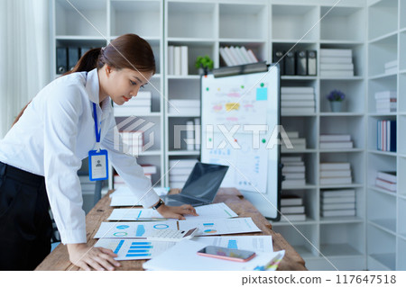 woman plans a finance and budget audit by reviewing organizing office financial documents woman plans a finance and budget audit by reviewing organizing office financial documents 117647518