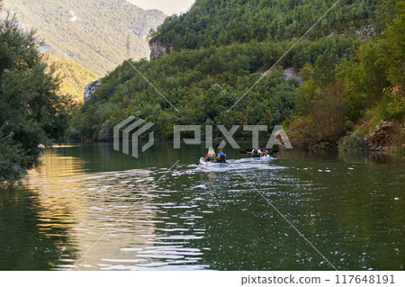 A group of friends enjoying having fun and kayaking while exploring the calm river, surrounding forest and large natural river canyons 117648191