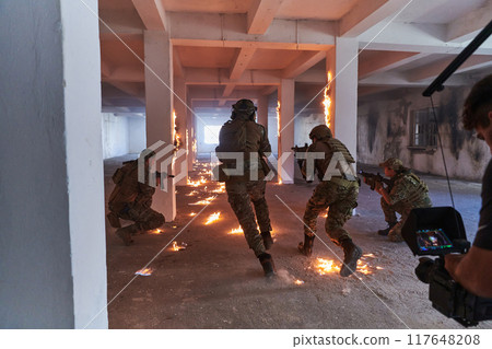 A professional cameraman captures the intense moments as a group of skilled soldiers embarks on a dangerous mission inside an abandoned building, their actions filled with suspense and bravery 117648208