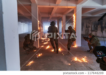 A professional cameraman captures the intense moments as a group of skilled soldiers embarks on a dangerous mission inside an abandoned building, their actions filled with suspense and bravery 117648209