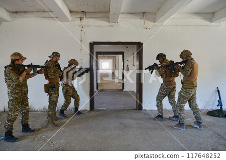 A group of professional soldiers bravely executes a dangerous rescue mission, surrounded by fire in a perilous building. 117648252