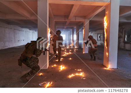 A group of professional soldiers bravely executes a dangerous rescue mission, surrounded by fire in a perilous building. 117648278