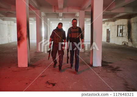 An abandoned building serves as the stronghold for a team of terrorists, fiercely guarding their occupied territory with guns and military equipment 117648321