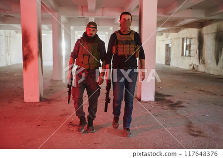 An abandoned building serves as the stronghold for a team of terrorists, fiercely guarding their occupied territory with guns and military equipment An abandoned building serves as the stronghold for a team of terrorists, fiercely guarding their occupied territory with guns and military equipment 117648376
