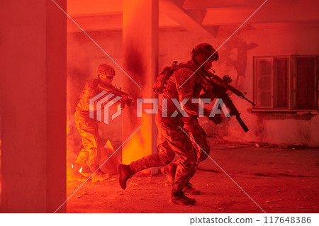 A group of professional soldiers bravely executes a dangerous rescue mission, surrounded by fire in a perilous building. 117648386