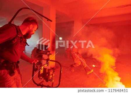 A professional cameraman captures the intense moments as a group of skilled soldiers embarks on a dangerous mission inside an abandoned building, their actions filled with suspense and bravery 117648431
