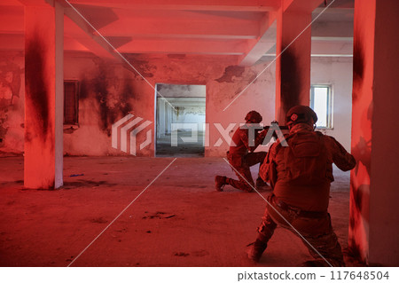 A group of professional soldiers bravely executes a dangerous rescue mission, surrounded by fire in a perilous building. 117648504