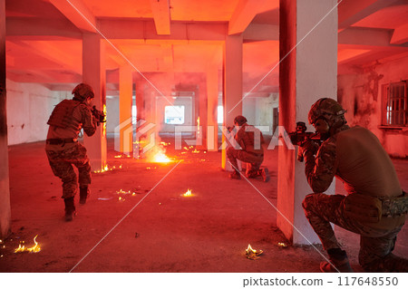 A group of professional soldiers bravely executes a dangerous rescue mission, surrounded by fire in a perilous building. A group of professional soldiers bravely executes a dangerous rescue mission, surrounded by fire in a perilous building. 117648550