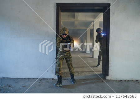 A group of professional soldiers bravely executes a dangerous rescue mission, surrounded by fire in a perilous building. 117648563