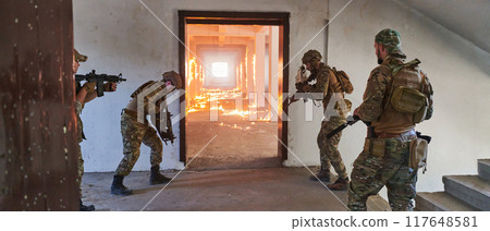 A group of professional soldiers bravely executes a dangerous rescue mission, surrounded by fire in a perilous building. A group of professional soldiers bravely executes a dangerous rescue mission, surrounded by fire in a perilous building. 117648581