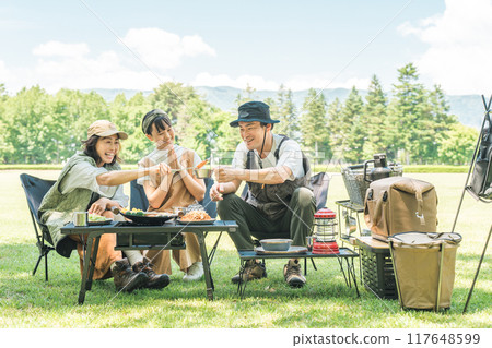 A friendly family enjoying day camping, camping and barbecues at a park or campsite A friendly family enjoying day camping, camping and barbecues at a park or campsite 117648599