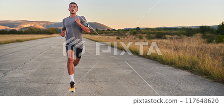 A young handsome man running in the early morning hours, driven by his commitment to health and fitness A young handsome man running in the early morning hours, driven by his commitment to health and fitness 117648620