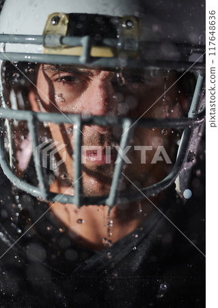 American Football Field: Lonely Athlete Warrior Standing on a Field Holds his Helmet and Ready to Play. Player Preparing to Run, Attack and Score Touchdown. Rainy Night with Dramatic Fog, Blue Light American Football Field: Lonely Athlete Warrior Standing on a Field Holds his Helmet and Ready to Play. Player Preparing to Run, Attack and Score Touchdown. Rainy Night with Dramatic Fog, Blue Light 117648636