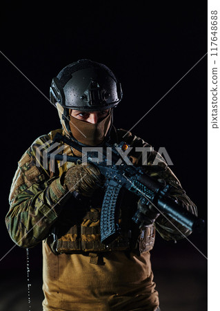 A professional soldier in full military gear striding through the dark night as he embarks on a perilous military mission A professional soldier in full military gear striding through the dark night as he embarks on a perilous military mission 117648688
