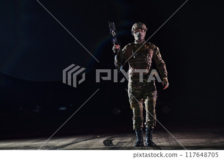 A professional soldier in full military gear striding through the dark night as he embarks on a perilous military mission A professional soldier in full military gear striding through the dark night as he embarks on a perilous military mission 117648705