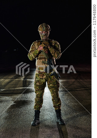 A professional soldier in full military gear striding through the dark night as he embarks on a perilous military mission A professional soldier in full military gear striding through the dark night as he embarks on a perilous military mission 117648800
