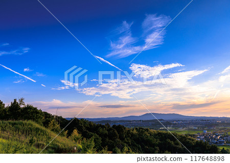 Evening view from a hill overlooking the town of Kizu in Kizugawa City, the southernmost part of Kyoto Prefecture. The sun is setting and the town of Kizu is illuminated by the setting sun #15 117648898