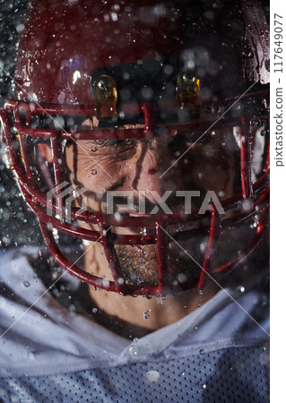 American Football Field: Lonely Athlete Warrior Standing on a Field Holds his Helmet and Ready to Play. Player Preparing to Run, Attack and Score Touchdown. Rainy Night with Dramatic Fog, Blue Light American Football Field: Lonely Athlete Warrior Standing on a Field Holds his Helmet and Ready to Play. Player Preparing to Run, Attack and Score Touchdown. Rainy Night with Dramatic Fog, Blue Light 117649077