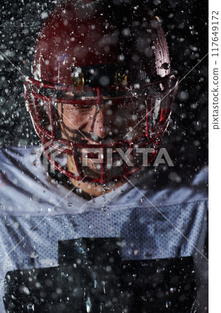 American Football Field: Lonely Athlete Warrior Standing on a Field Holds his Helmet and Ready to Play. Player Preparing to Run, Attack and Score Touchdown. Rainy Night with Dramatic Fog, Blue Light American Football Field: Lonely Athlete Warrior Standing on a Field Holds his Helmet and Ready to Play. Player Preparing to Run, Attack and Score Touchdown. Rainy Night with Dramatic Fog, Blue Light 117649172