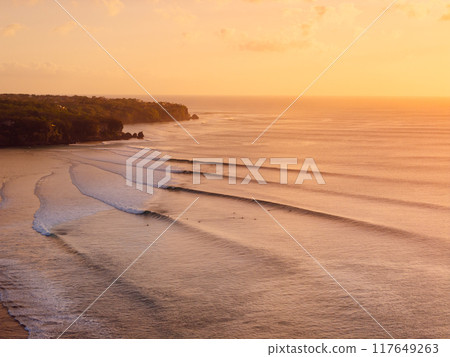 Drone view of warm sunset or sunrise and ocean with perfect long waves in Bali. 117649263