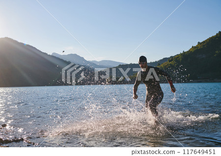 Triathlon athlete starting swimming training on lake 117649451