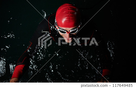 A triathlete finds serene rejuvenation in a lake, basking in the tranquility of the water after an intense training session A triathlete finds serene rejuvenation in a lake, basking in the tranquility of the water after an intense training session 117649485