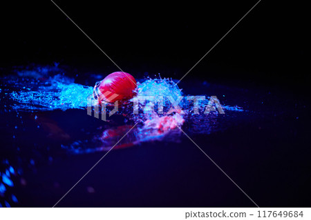 Authentic triathlete swimmer having a break during hard training on night neon gel light 117649684