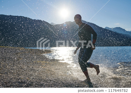 Triathlon athlete starting swimming training on lake 117649782