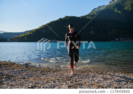 Triathlon athlete starting swimming training on lake 117649800