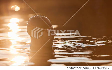 A triathlete finds serene rejuvenation in a lake, basking in the tranquility of the water after an intense training session A triathlete finds serene rejuvenation in a lake, basking in the tranquility of the water after an intense training session 117649817